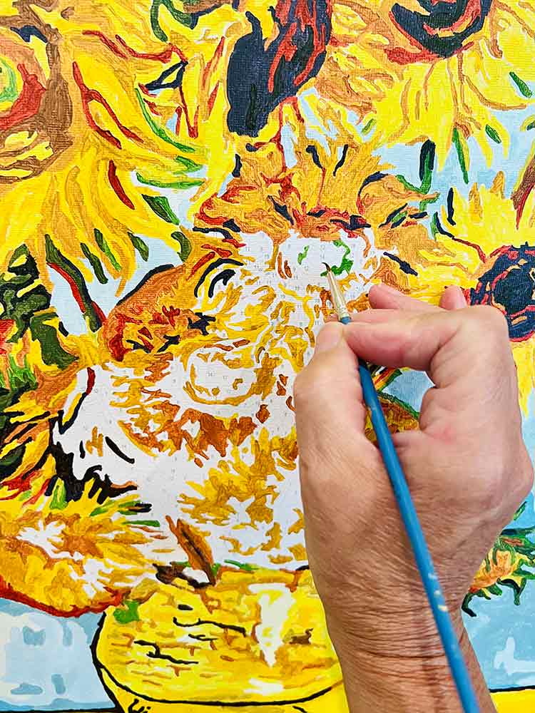 Mano con pennello crea Falso d'Autore Girasoli, copiando opera d'arte originale, tecnica creazione copie